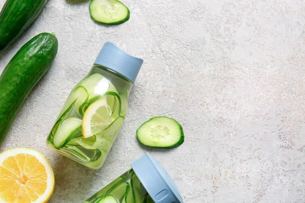 stock image Sports bottles of infused water with cucumber slices on grey background