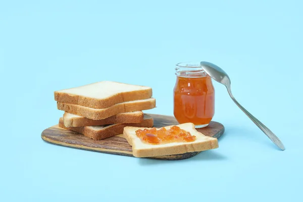 Wooden Board Tasty Toasts Jar Apricot Jam Spoon Blue Background — Stock Photo, Image