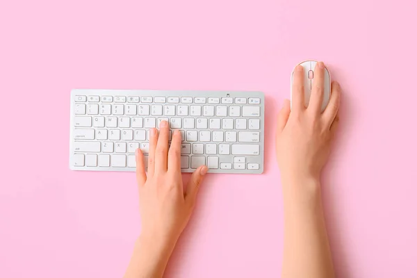 女性手ともに現代的なコンピュータキーボードとマウスのピンクの背景 — ストック写真