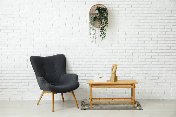 深色灰色扶手椅 有咖啡桌 室内植物和白色砖墙旁边的地毯 — 图库照片