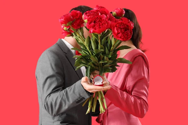 Pareja Joven Con Anillo Compromiso Flores Sobre Fondo Rojo — Foto de Stock