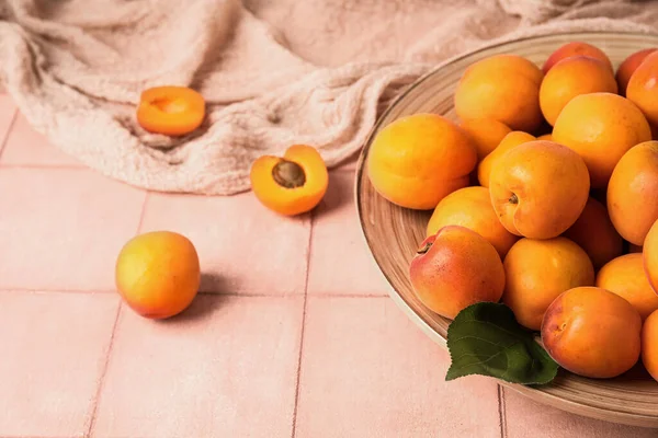 Teller Mit Frischen Aprikosen Auf Rosa Fliesentisch — Stockfoto