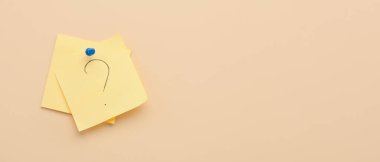 Bej arkaplan üzerinde soru işareti olan yapışkan kağıtlar ve metin için boşluk