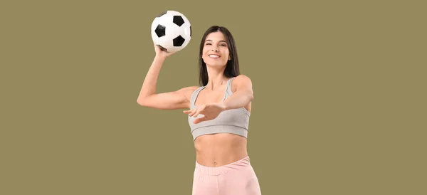 一个身材矮小的年轻女子把足球扔在彩色的背景下 — 图库照片