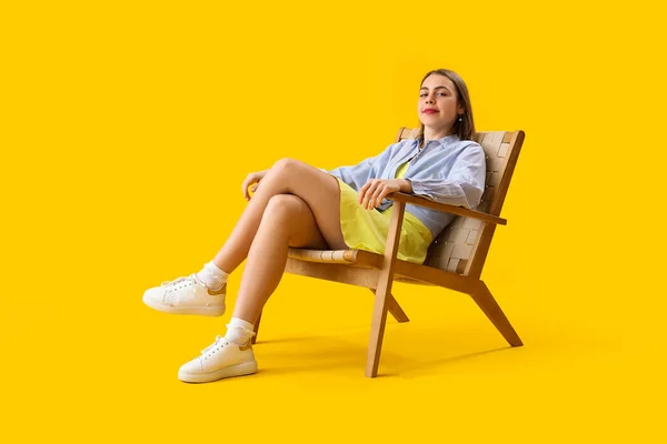 Mujer Joven Sentada Sillón Madera Sobre Fondo Amarillo — Foto de Stock