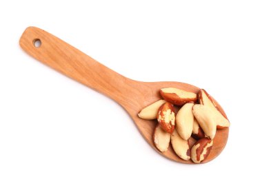 Beyaz arka planda lezzetli Brezilya fıstığı olan tahta kaşık.