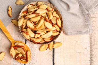 Bir kase dolusu leziz Brezilya fıstığı açık ahşap masada.