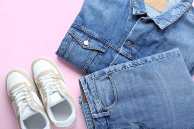 Kot ceketli şık kotlar ve pembe arka planda spor ayakkabılar.