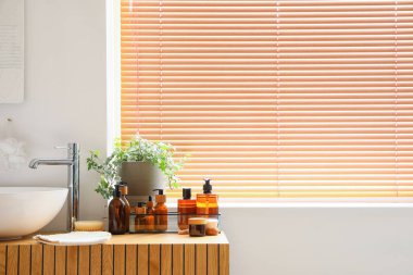 Banyo aksesuarları odanın penceresinin yanındaki masada lavabo var.