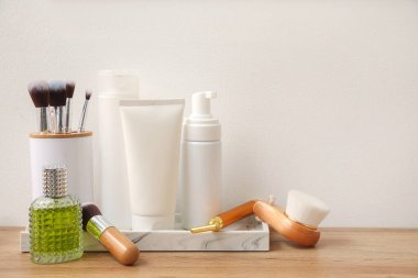 Işık duvarının yanındaki masada fırçalı banyo aksesuarları.