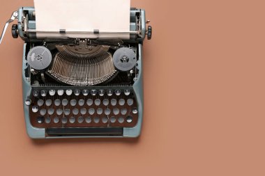 Kahverengi zemin üzerinde boş kağıt levhası olan klasik daktilo