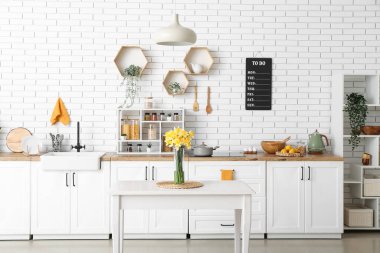 Mutfağın içindeki masada çiçek açan vazo.