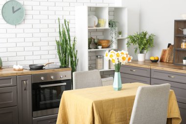 Masada vazo içinde çiçek açan modern mutfaktan.