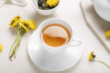 Beyaz arka planda bir fincan sağlıklı karahindiba çayı.