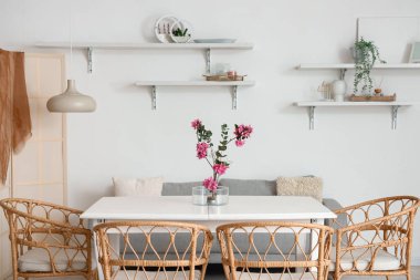 Masada ve raflarda ikebana olan yemek odasının içinde.