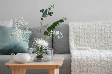 Oturma odasındaki çaydanlığı olan güzel Ikebana.