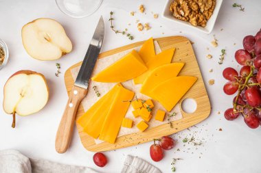 Hafif arka planda lezzetli çedar peynirli ahşap tahta.