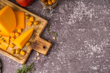 Lezzetli çedar peyniri, zeytin ve kekik arkaplanda.