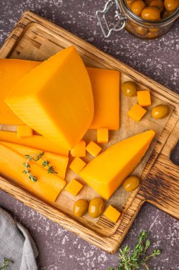 Lezzetli çedar peyniri, zeytin ve kekik arkaplanda.