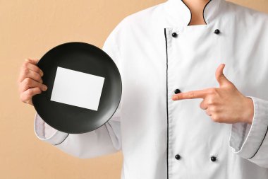 Bej arka planda boş kartı olan kadın şef, yakın plan.