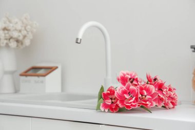 Mutfakta güzel lalelerle lavabo, yakın çekim