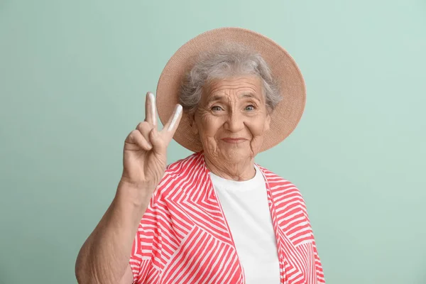 Senior Woman Sunscreen Cream Showing Victory Gesture Green Background — Stock Photo, Image
