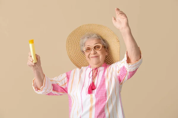 Seniorin Mit Sonnencreme Auf Beigem Hintergrund — Stockfoto