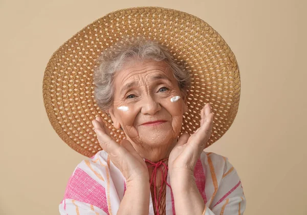 Seniorin Mit Sonnencreme Gesicht Vor Beigem Hintergrund Nahaufnahme — Stockfoto