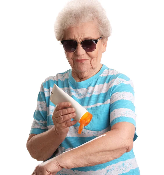 Seniorin Trägt Sonnencreme Auf Weißem Hintergrund Auf — Stockfoto