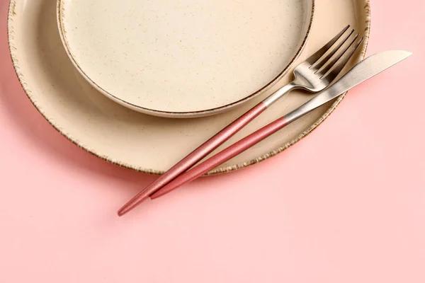 粉色背景的带干净盘子和餐具的餐桌布置 — 图库照片