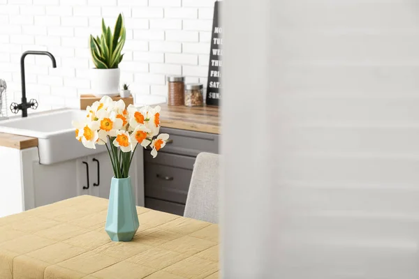 現代のキッチンでテーブルの上に咲くナルシシズムの花と花瓶 屏風の後ろに表示 — ストック写真