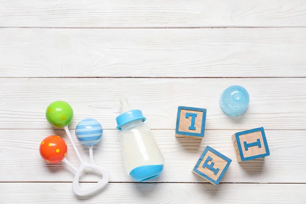 Bottle Milk Baby Toys Rattle White Wooden Background — Stock Photo, Image