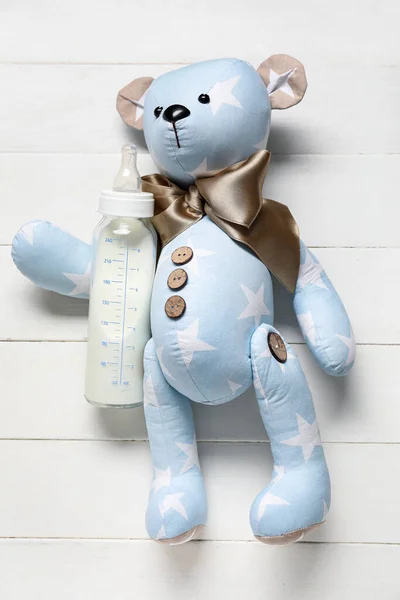 Медвежонок Бутылкой Молока Малыша Белом Деревянном Фоне — стоковое фото