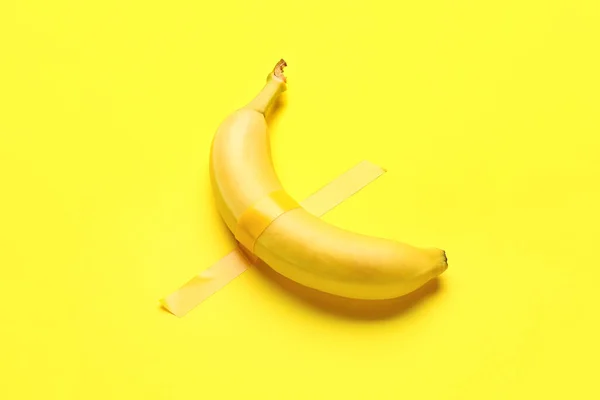 Banane Avec Ruban Adhésif Sur Fond Jaune — Photo