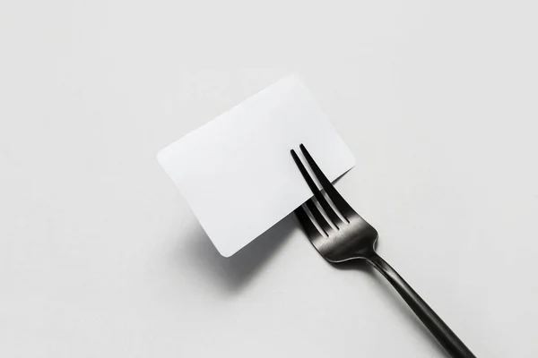 空白のカードと白い背景のステンレス製のフォーク — ストック写真