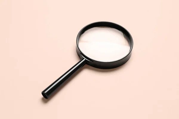 浅粉色背景的黑色放大镜 — 图库照片