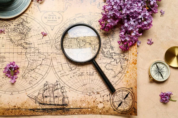 Världskarta Med Kompass Förstoringsglas Och Lila Blommor Beige Grunge Bakgrund — Stockfoto