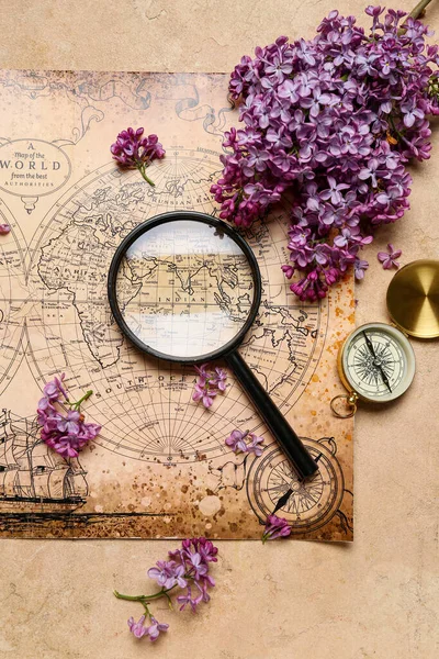Världskarta Med Kompass Förstoringsglas Och Lila Blommor Beige Grunge Bakgrund — Stockfoto