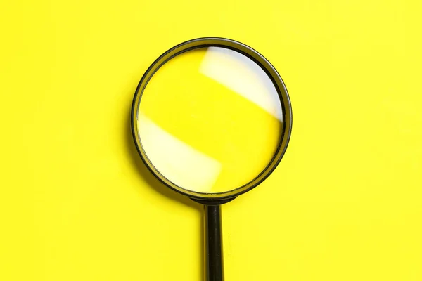 黄色背景的黑色放大镜 — 图库照片