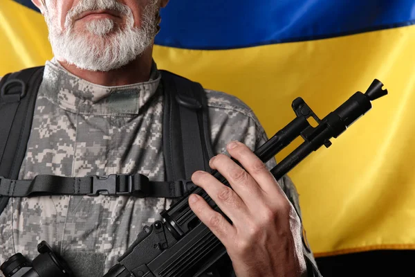 Dojrzały Żołnierz Karabinem Szturmowym Przeciwko Fladze Ukrainy Zbliżenie — Zdjęcie stockowe