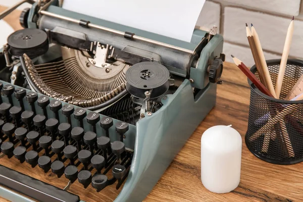Vintage Skrivmaskin Med Pennhållare Och Ljus Brunt Träbord Nära Tegelvägg — Stockfoto