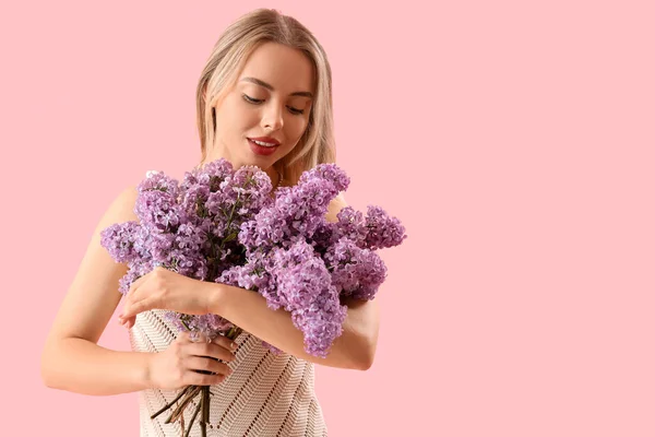 Pembe Arka Planda Leylak Çiçekleri Olan Genç Bir Kadın — Stok fotoğraf