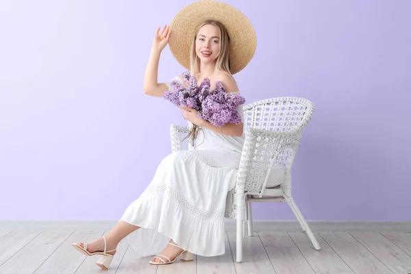 Ung Kvinna Med Syren Blommor Fåtölj Nära Färg Vägg — Stockfoto