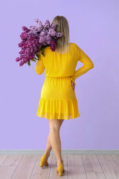 Ung Kvinna Med Lila Blommor Nära Färg Vägg Baksida — Stockfoto
