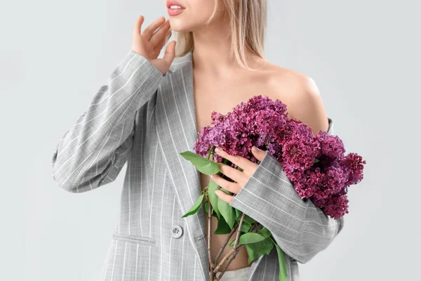 薄い背景にライラックの花を持つ若い女性 クローズアップ — ストック写真