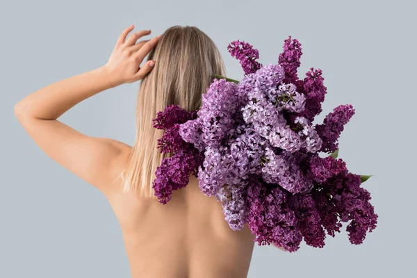 Naken Ung Kvinna Med Lila Blommor Ljus Bakgrund Baksida — Stockfoto