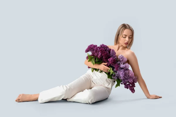Young Woman Lilac Flowers Sitting Light Background — Stock Photo, Image