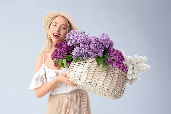 Ung Kvinna Med Korg Med Lila Blommor Ljus Bakgrund — Stockfoto