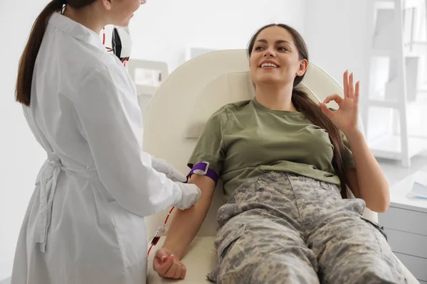 医生在诊所从女兵身上取血 — 图库照片