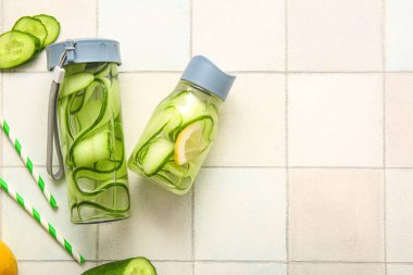 Beyaz fayanslı salatalık dilimli spor şişeleri.